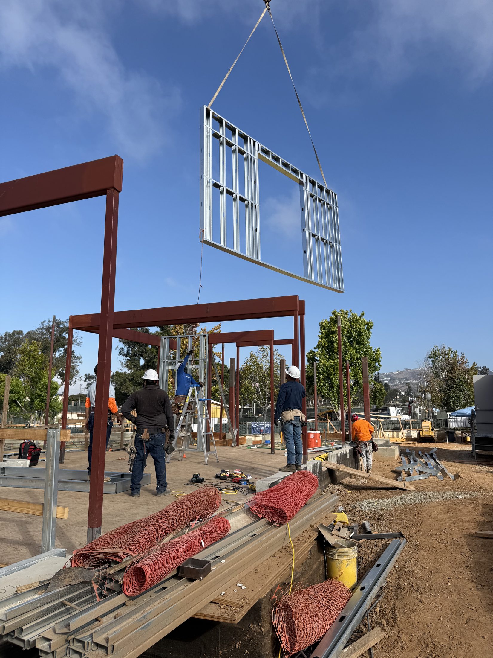 The crew guiding a steel-framed section into position at 777 Ocampo