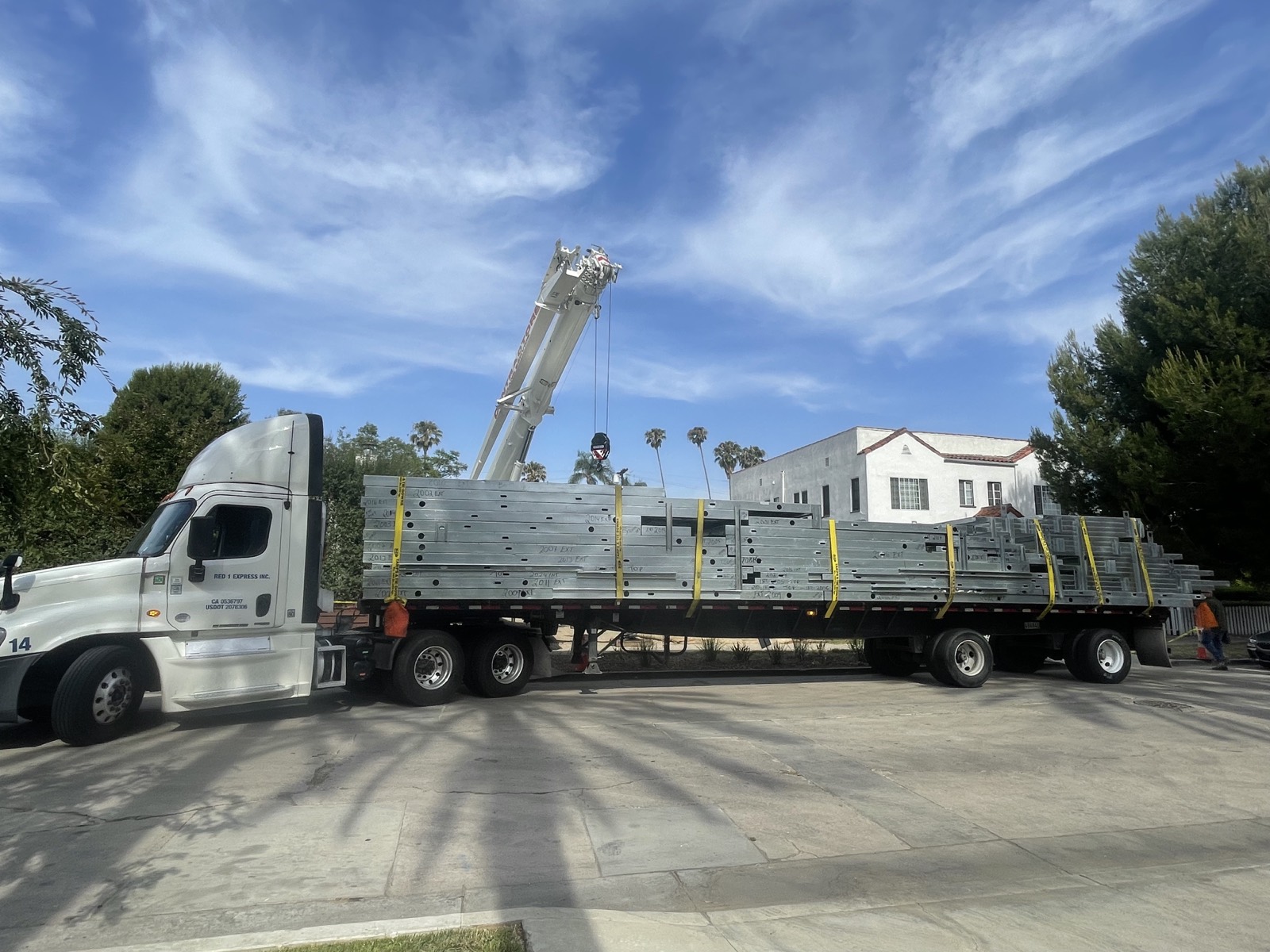 Structural steel and panels delivered by crane truck and staged on site