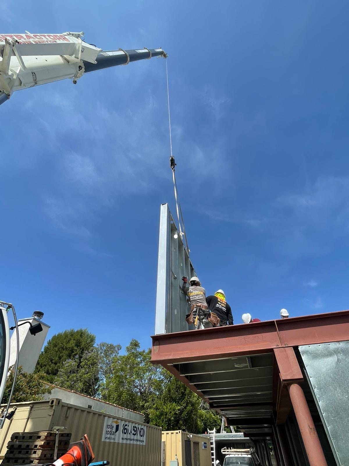 A panelized wall section craned onto the structural steel deck at 823 North June Street
