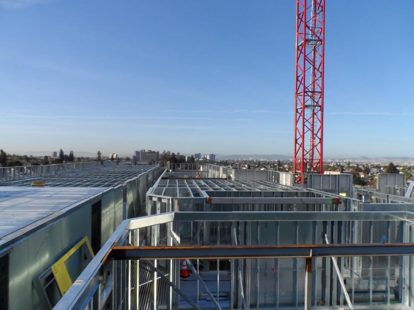 Steel framing of the Merrill Gardens Oakland development under construction with a tower crane.