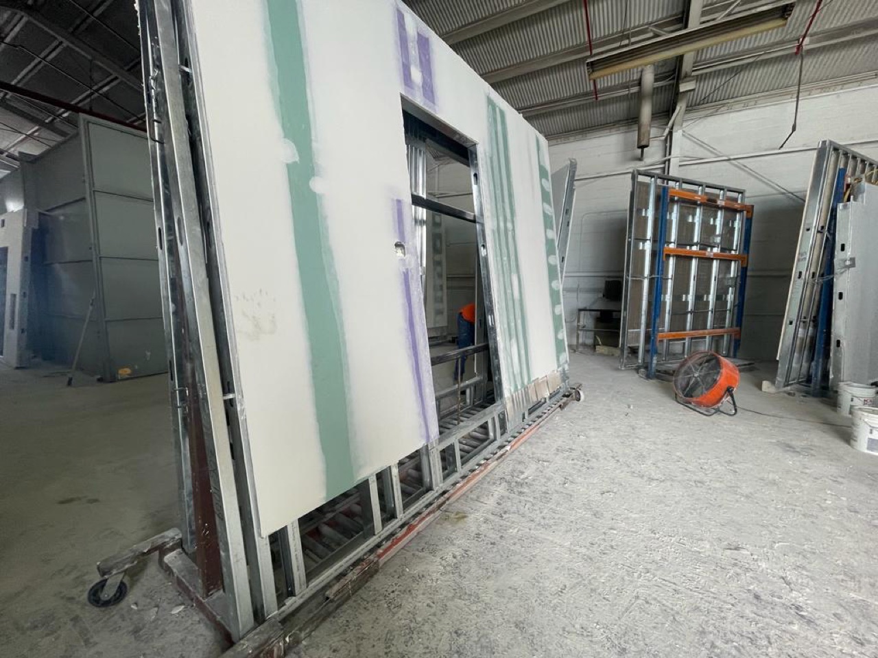 Interior wall panels of a module with taped and finished drywall inside the factory